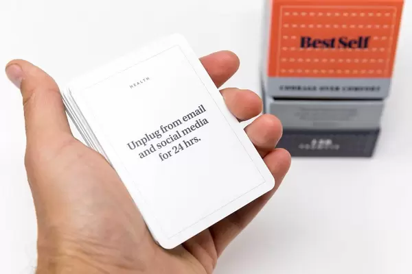 Ein Tag ohne Social-Media: Hand hält eine Aufgabenkarte aus dem BestSelf Courage over Comfort-Deck