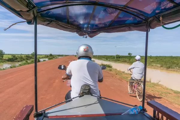 Ein TukTuk überholt einen Mann auf dem Fahrrad in Siem Reap