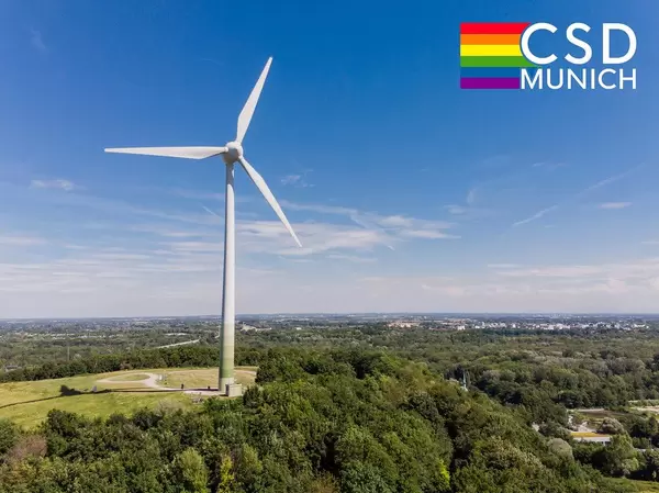 Ein Windrad nahe der Allianzarena in München, neben einer Regenbogenflagge und dem Bildtitel "CSD Munich", um den Christopher Street Day zu feiern