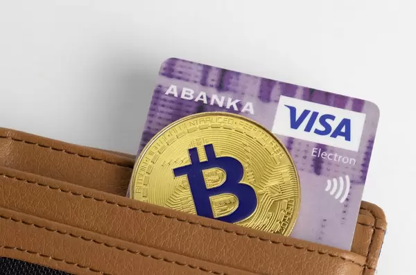 Eine Bitcoin-Münze mit einer VISA-Karte in einer Geldbörse