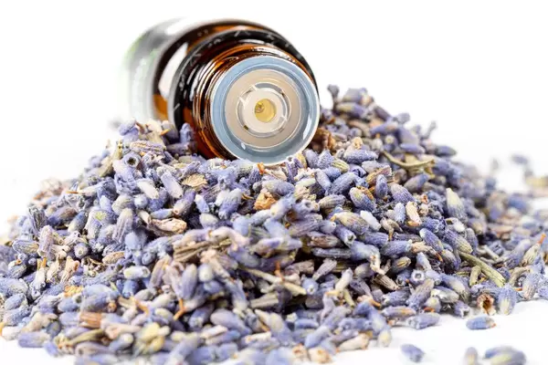 Eine Flasche ätherische Öle auf Lavendelblüten. Nahaufnahme