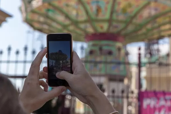 Eine Frau fotografiert ein Karussell im Prater