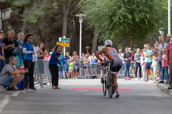 Eine Frau gibt das Startsignal für einen Radfahrer bei einem Triathlon