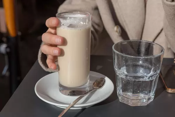 Eine Frau trinkt einen Latte Macchiatto in einem Cafe in Rom