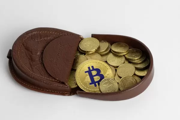 Eine Geldbörse mit Eurocent Münzen und einem Bitcoin