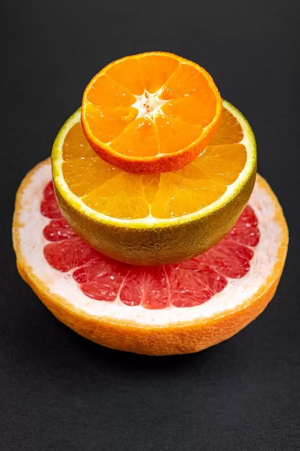 Eine halbe Orange, Grapefruit und ein halber Mandarin for schwarzem Hintergrund