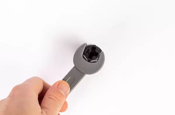 Eine Hand löst eine Schraube mit einem Scharaubenschlüssel