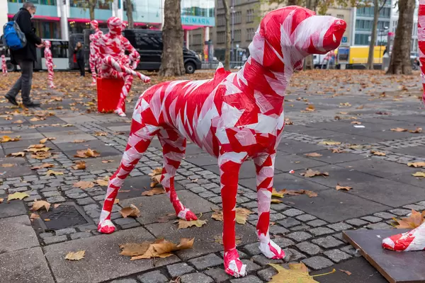 Eine Hundfigur wrapped in red-white barrier tape as part of the Covid-19 art installation "It is like it is"