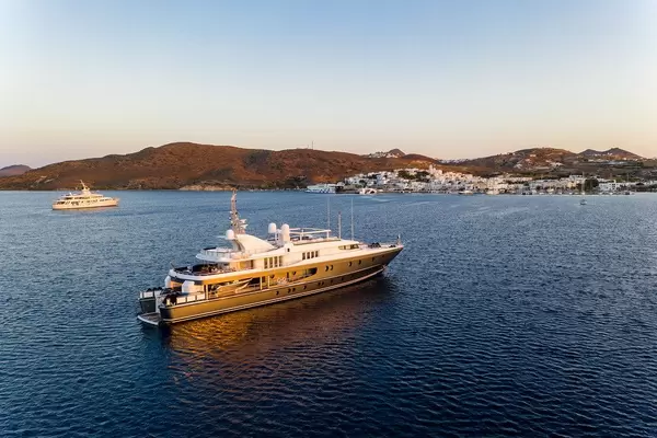 Eine Jacht fährt Richtung Hafen am Sonnenuntergang auf Milos, Griechenland