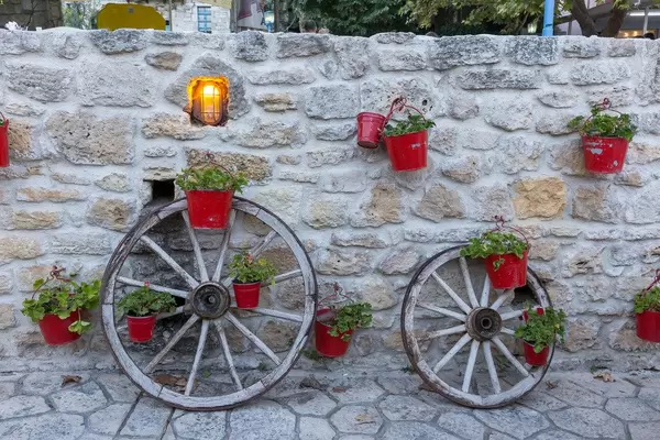 Eine Mauer mit roten Blumeneimern in Afitos