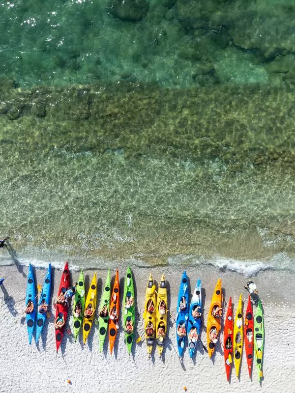 Eine Reihe von Kajaks in verschiedenen Farben am Strand von Milia, Skopelos. Luftbild