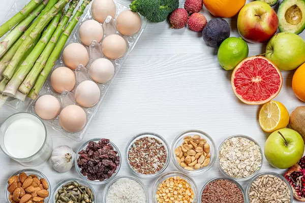 Eine Reihe von Lebensmitteln, die für das Gehirn nützlich sind, auf einem weißen, hölzernen Hintergrund mit freiem Platz