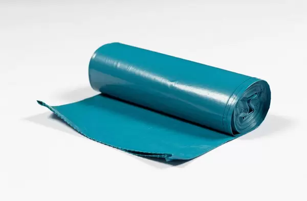 Eine Rolle blauer Müllbeutel auf weißem Hintergrund