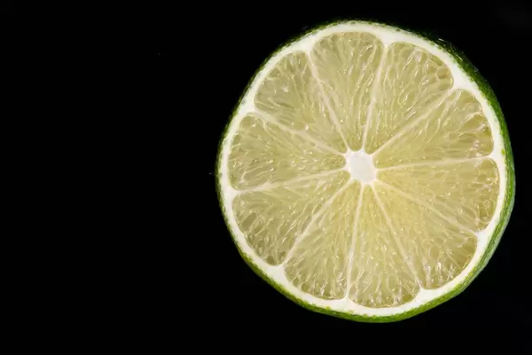 Eine Scheibe einer Limette, auf schwarzem Untergrund