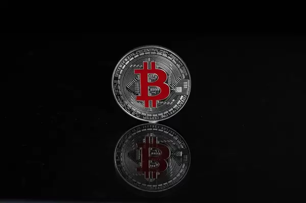 Eine silberne Bitcoin-Münze auf schwarzem Hintergrund