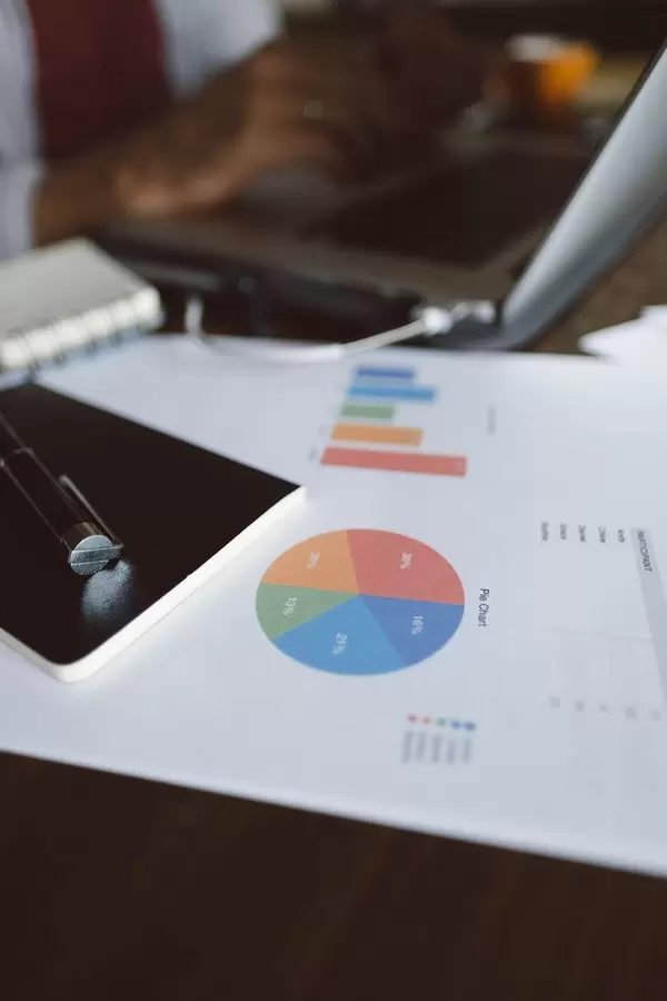 Eine Statistik auf einem Dokument mit einem Mann der an einem Computer arbeitet im Hintergrund