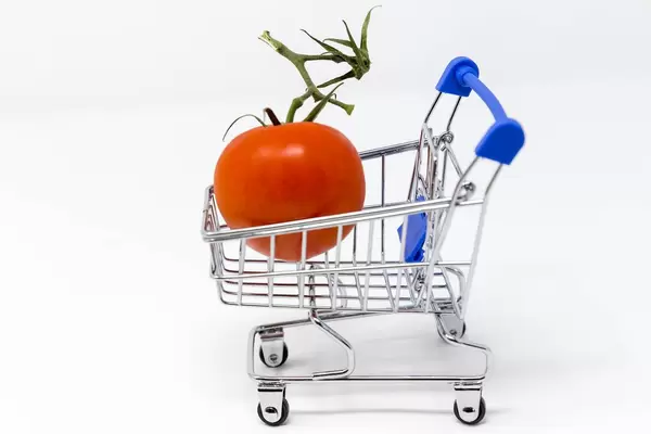 Eine Tomate in einem kleinen Einkaufswagen