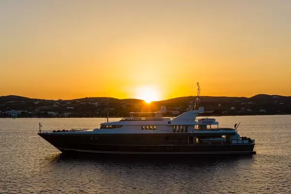 Eine Yacht und der Sonnenuntergang am Hafen von Adámas, Milos, Griechenland