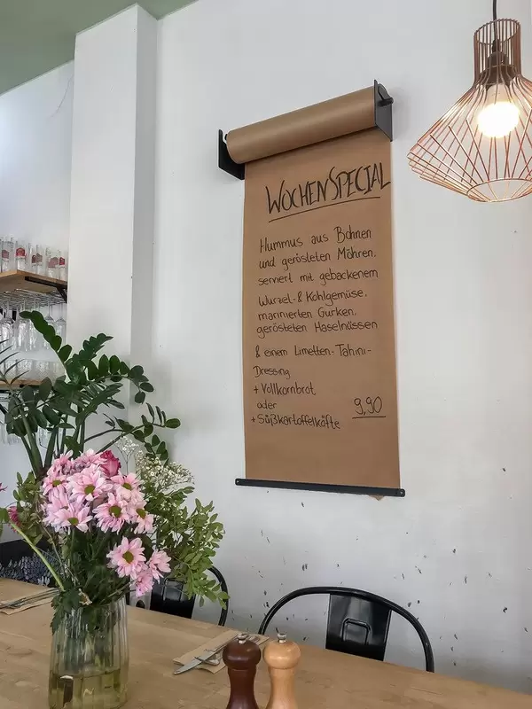 Einfache Menükarte mit dem Wochen-Spezial, an der Wand des Edelgrün-Restaurants in Köln