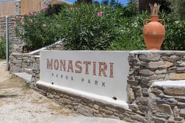 Eingangsschild des Cafés und Restaurants Monastiri im Paros Park in Griechenland