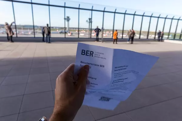 Einige Menschen beobachten die Flugzeuge aus der Besucherterrasse vom Terminal 1 am Flughafen BER