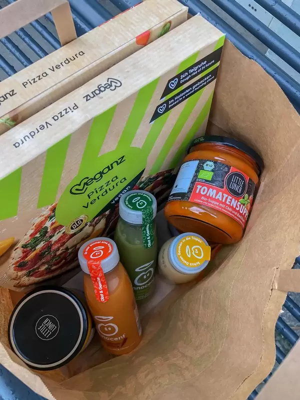 Einkauf von gesunden Lebensmitteln wie Tomatensuppe, veganer Pizza und Fruchtsäften