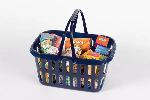 Einkaufskorb randvoll gefüllt mit Supermarkt-Produkten vor weißem HIntergrund