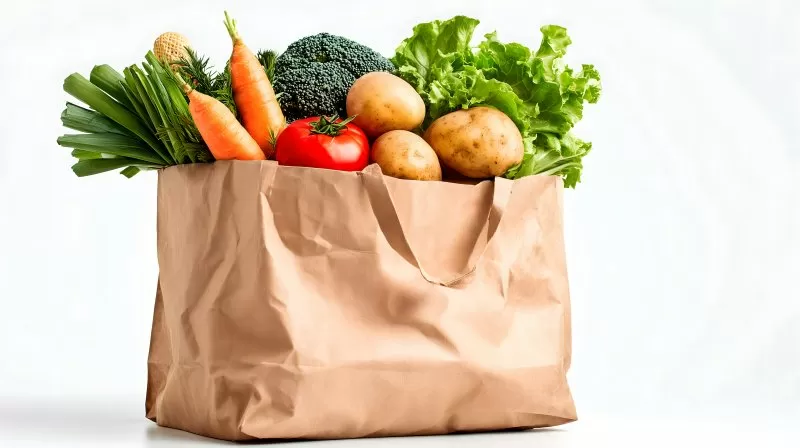 Einkaufstüte mit Kartoffeln Tomaten und grünem Gemüse