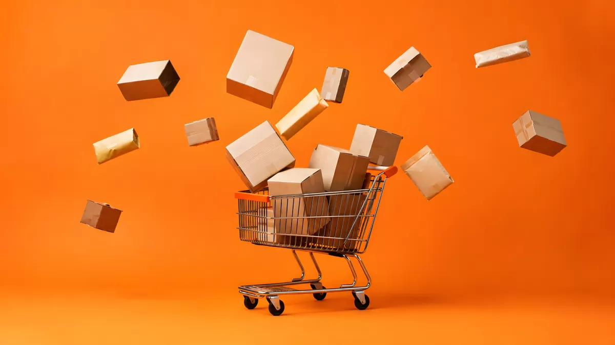 Einkaufswagen mit fliegenden Paketen auf orangem Hintergrund