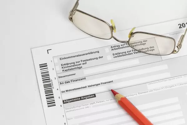 Einkommenssteuererklärung mit Brille und einem Buntstift