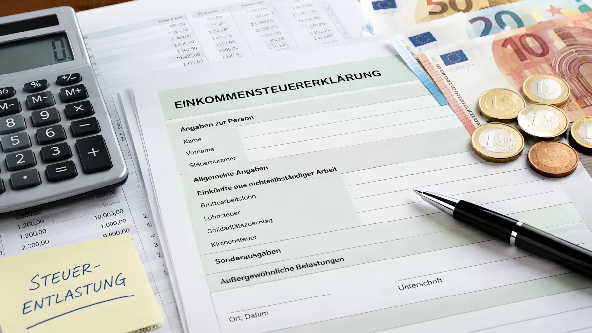 Einkommensteuererklärung mit Euro-Scheinen und Taschenrechner