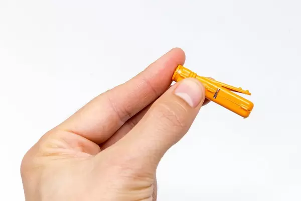 Einstichnadel des Gluten-Intoleranz Selbst-Tests sticht in einen Finger