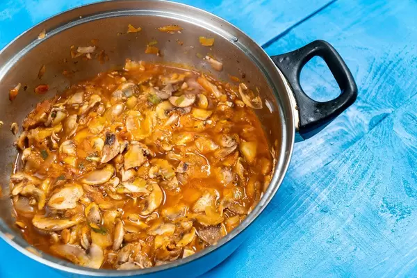 Eintopf mit Hähnchen und Pilzen in einem Topf Nahaufnahme