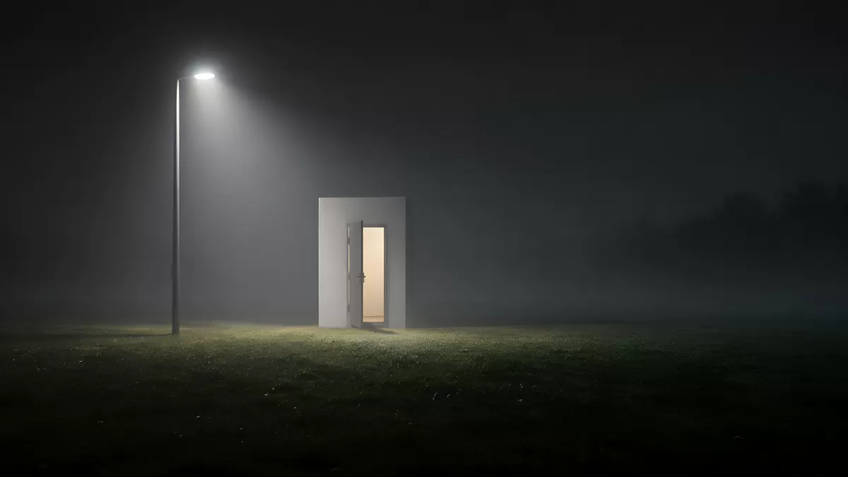 Einzelne Tür im Nebel mit warmem Licht in der Nacht