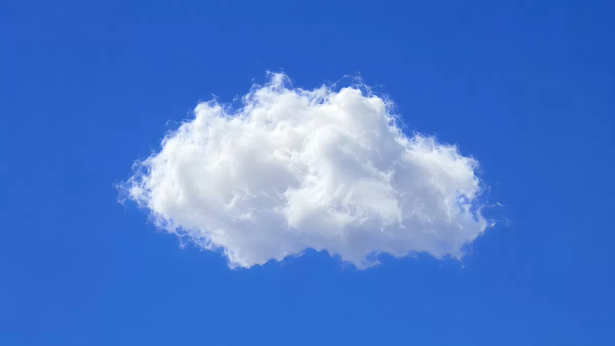 Einzelne weiße Kumuluswolke am blauen Himmel