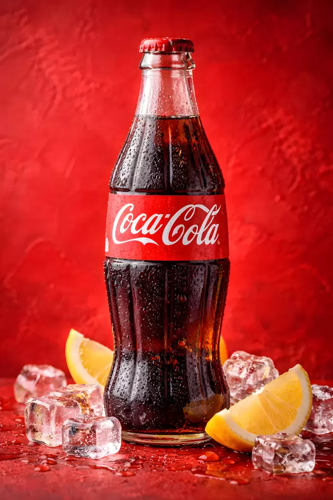 Eiskalte Erfrischung: Vintage Coca-Cola-Flasche vor rotem Hintergrund