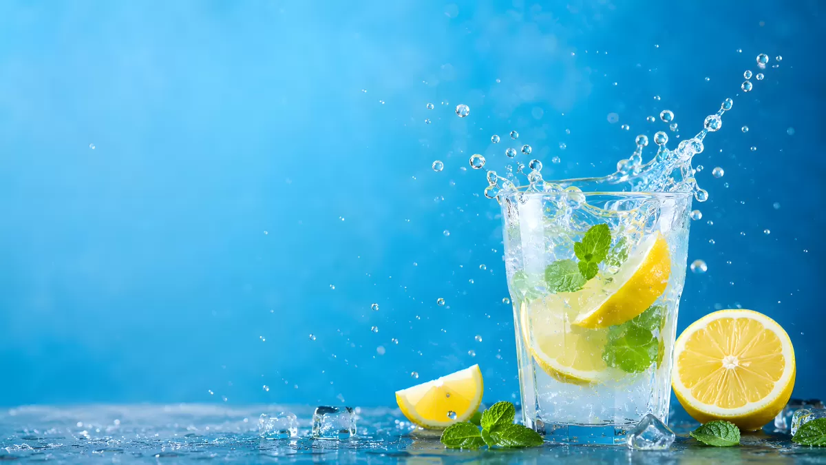 Eiskaltes Zitronenwasser mit Minze und Spritzeffekt
