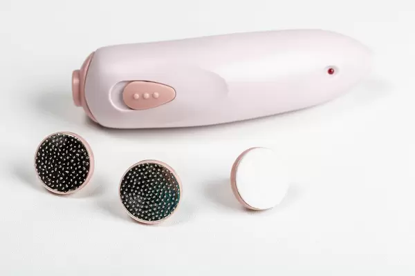 Electric manicure machine with attachments on a white background