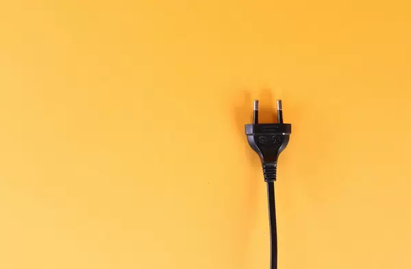 Electric plug on orange background