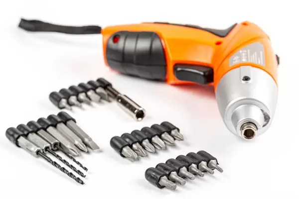 Electric screwdriver on white background with bits and drills