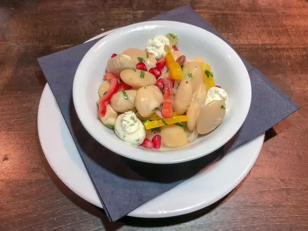 Elefantenbohnen-Salat mit Granatapfel und Ziegenkäsecreme. Nahaufnahme