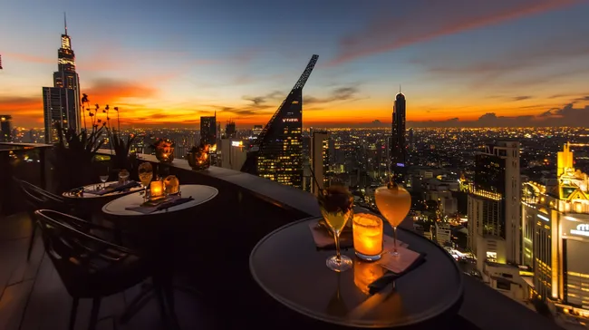 Elegante Dachterrasse mit Blick auf Bangkok bei Sonnenuntergang