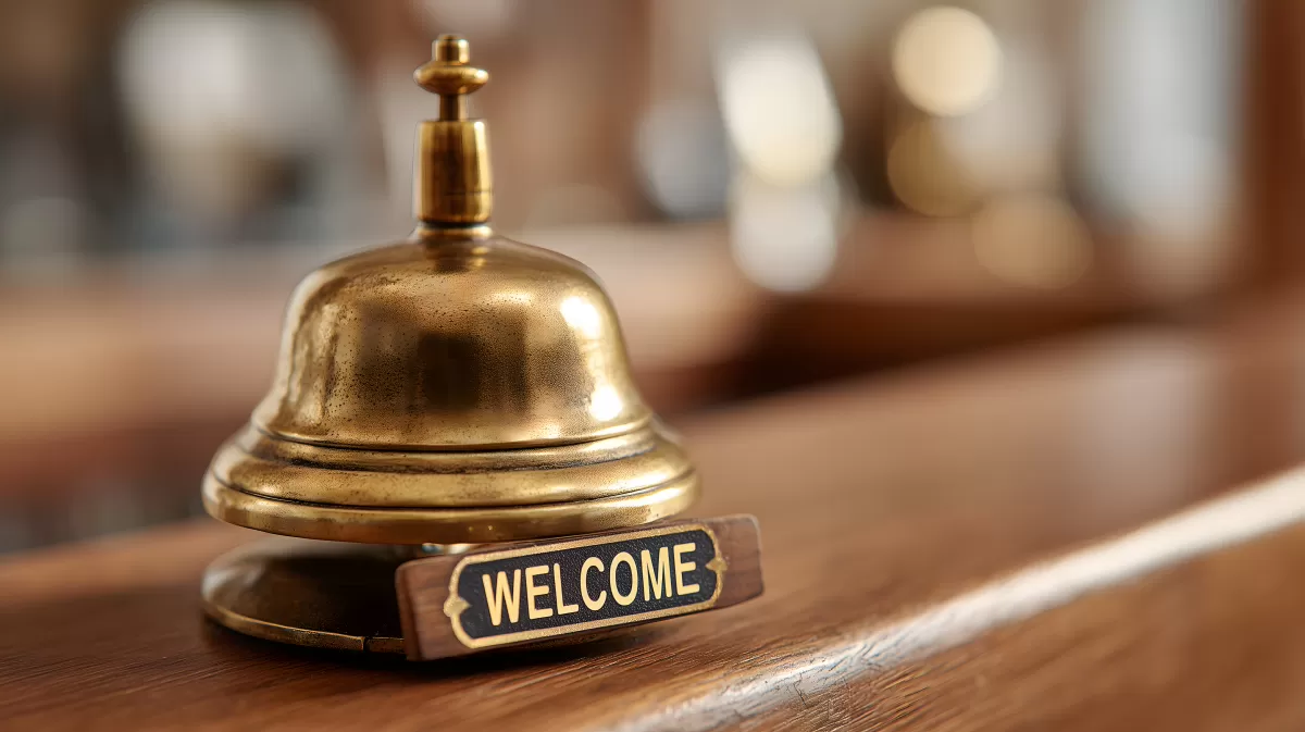 Elegante Hotelklingel mit Willkommensschild auf Holztheke