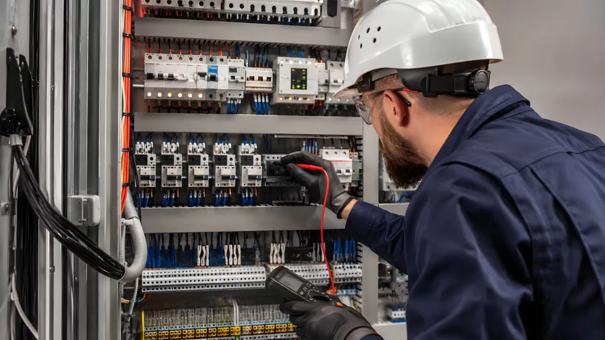 Elektriker prüft Schaltschrank mit Messgerät