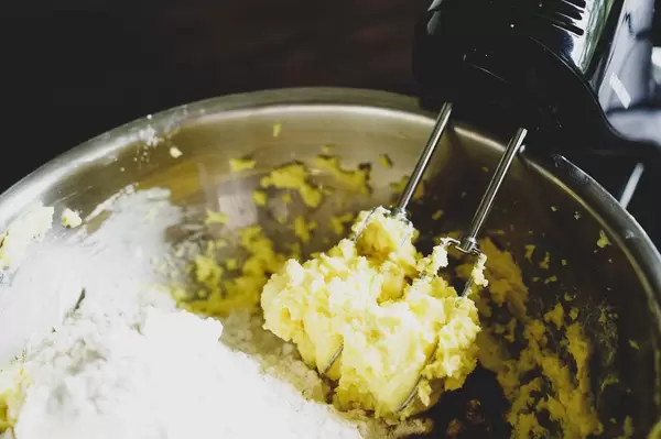 Elektrisches Handrührgerät mit Kuchenteig in Backschüssel