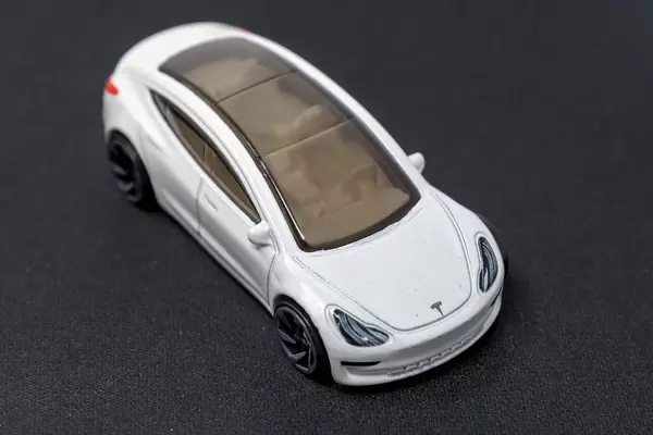 Elektroauto als Spielzeug;: Hot Wheels Tesla mit Glasdach, auf dunkler Oberfläche