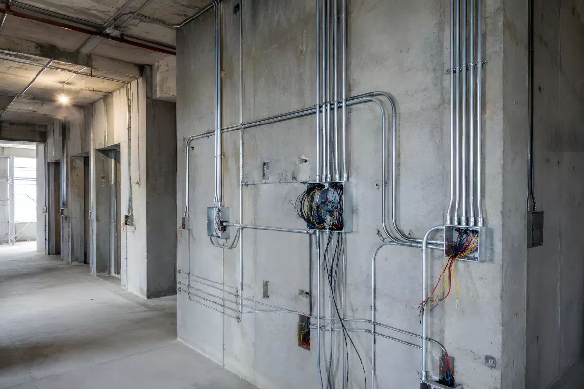 Elektroinstallation mit Metallrohren an Betonwand