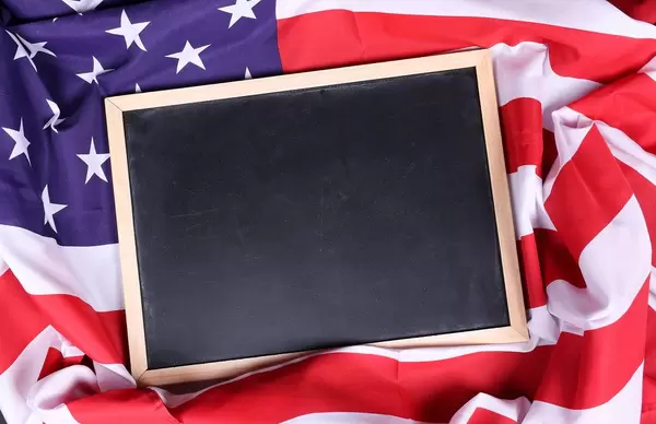 Empty chalkboard on American flag