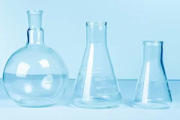 Empty flasks on a light blue background. Laboratory glassware (Flip 2020)