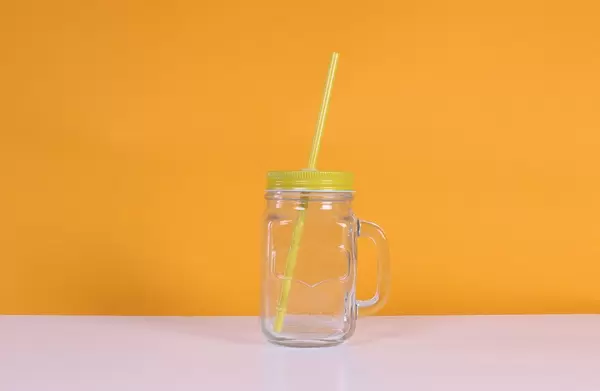Empty mason jar on orange background